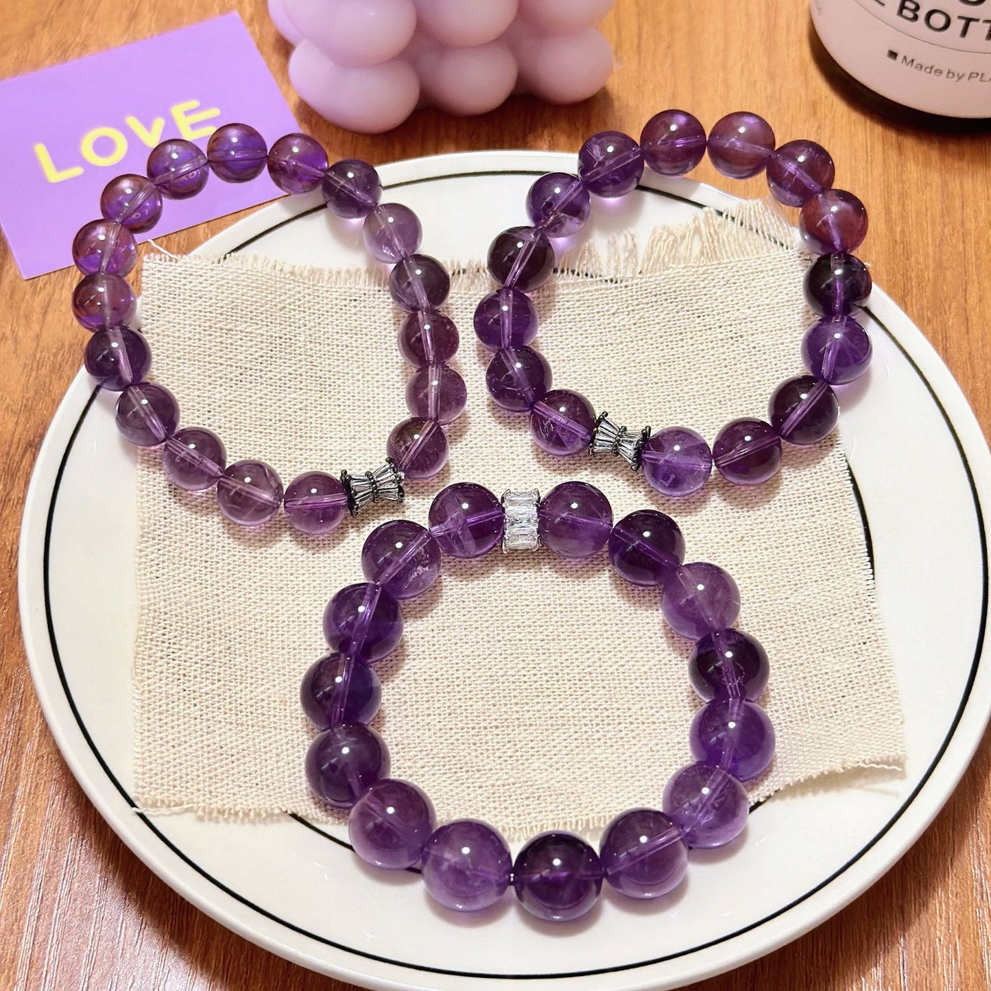 Natural amethyst crystal bead bracelets displayed on plate showing purple healing crystal jewelry