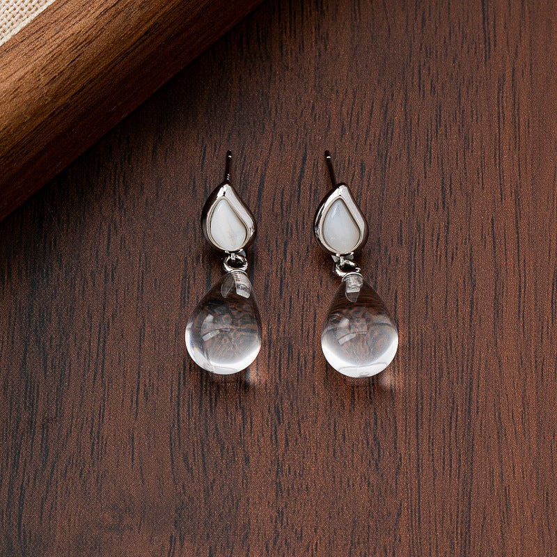 aurimala-minimalist-clear-quartz-mother-of-pearl-teardrop-earrings Brown background