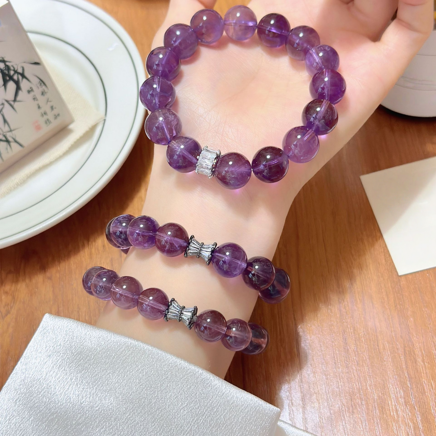Woman wearing natural amethyst crystal bead bracelet for calm energy and spiritual balance